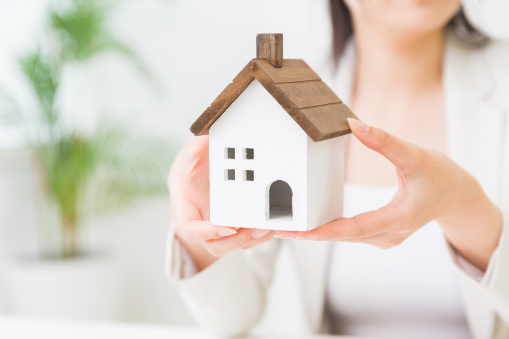 woman holding house