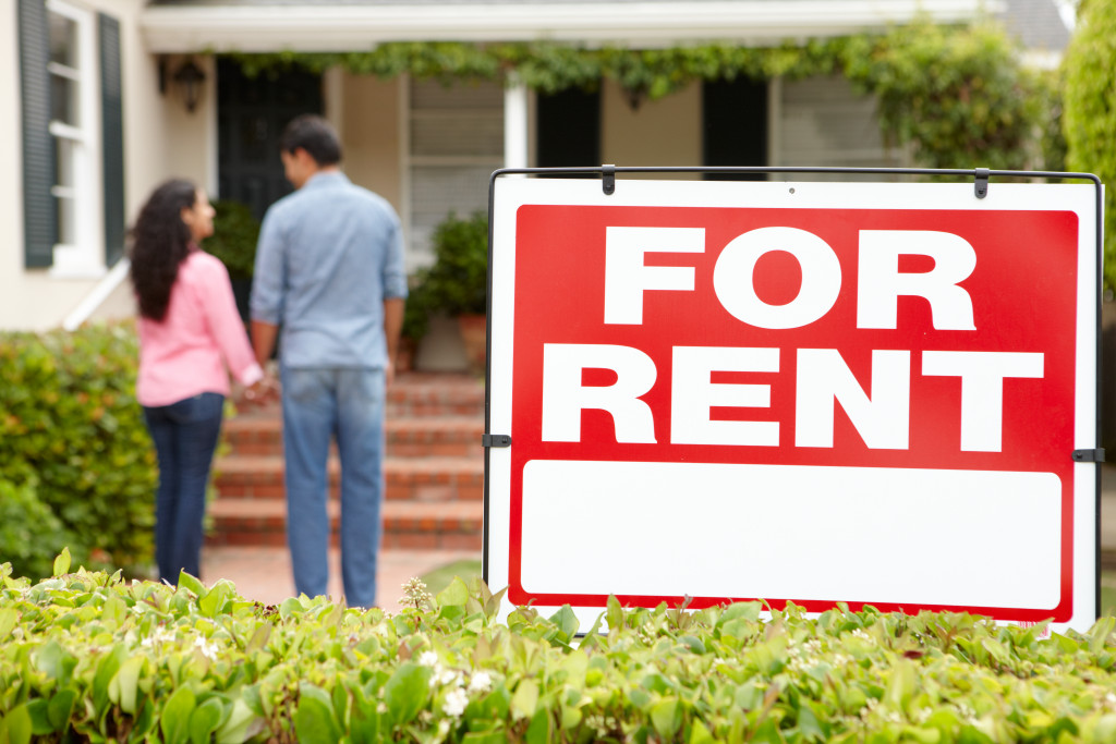 Hispanic couple outside home for rent