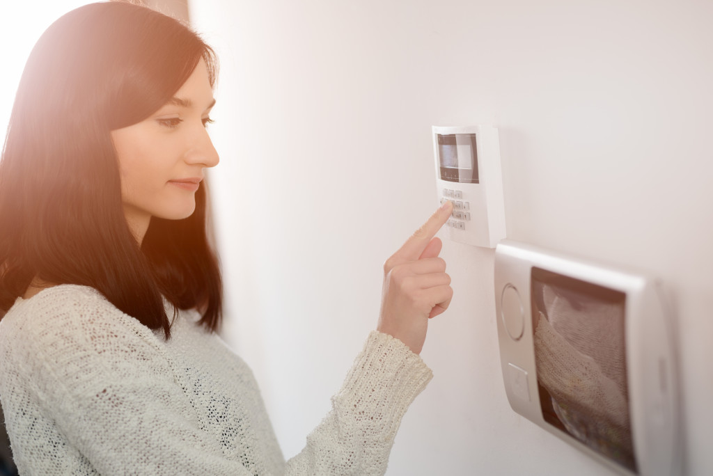 On the wall, a mother is checking the security system monitor.