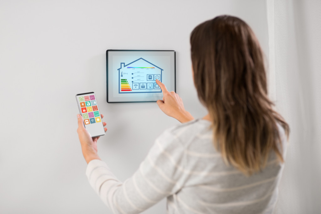 Woman controlling house temperature using touchscreen panel
