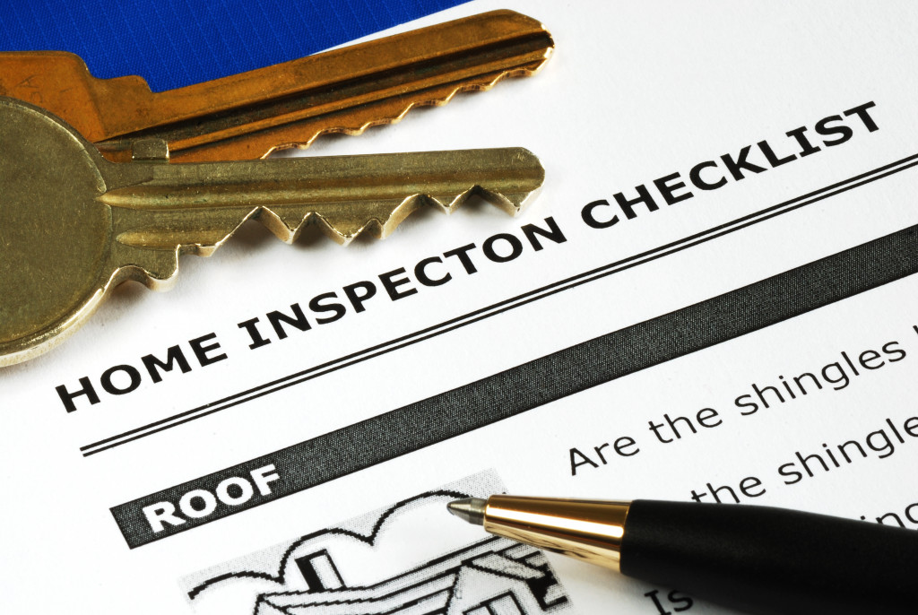 Roof inspection checklist with a pen and keys