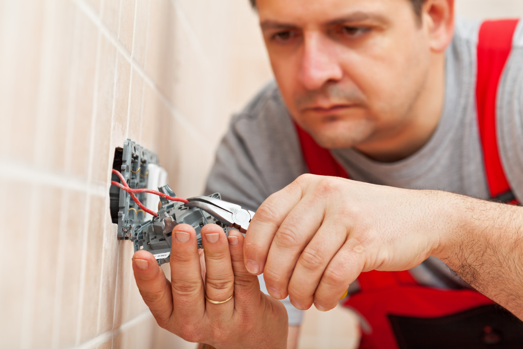 Electrician working on electrical wall fixture