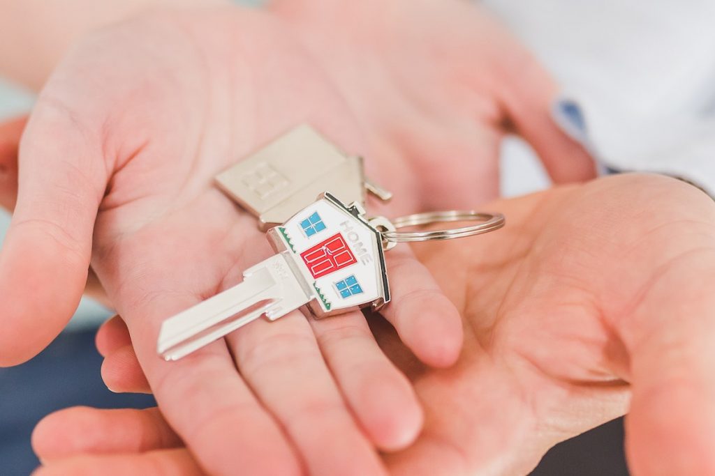 People Holding a House Shaped Key