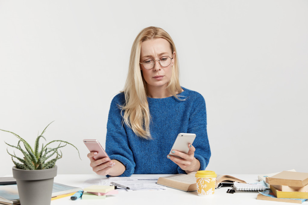 A woman using two mobile phones at a time