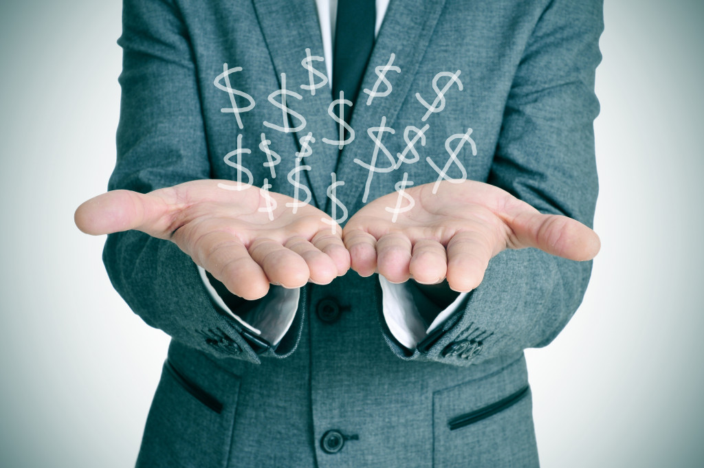 businessman showing dollar sign in hands